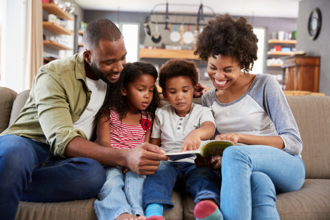 Family,Sitting,On,Sofa,In,Lounge,Reading,Book,Together The Brain Health Benefits of Reading