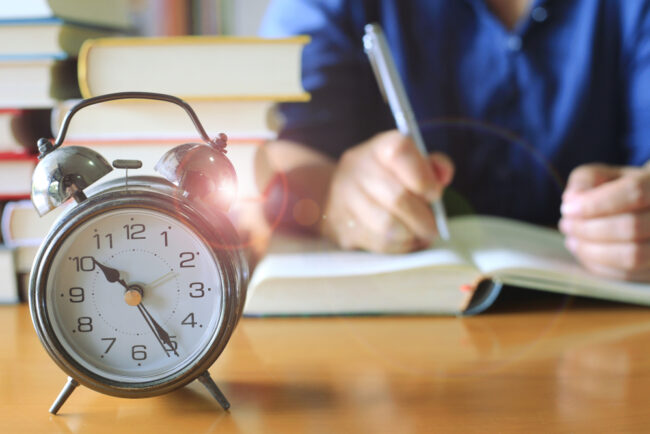 Close-up,Of,Old,Antique,Alarm,Clock,On,Table,In,Library